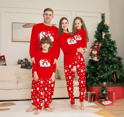 Family of four wearing matching red Christmas pajamas with polar bear and snowflake print, standing by a Christmas tree. - Image 4