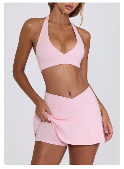 Light pink halter neck sports bra and high-waisted leggings workout set on a model. - Image 43