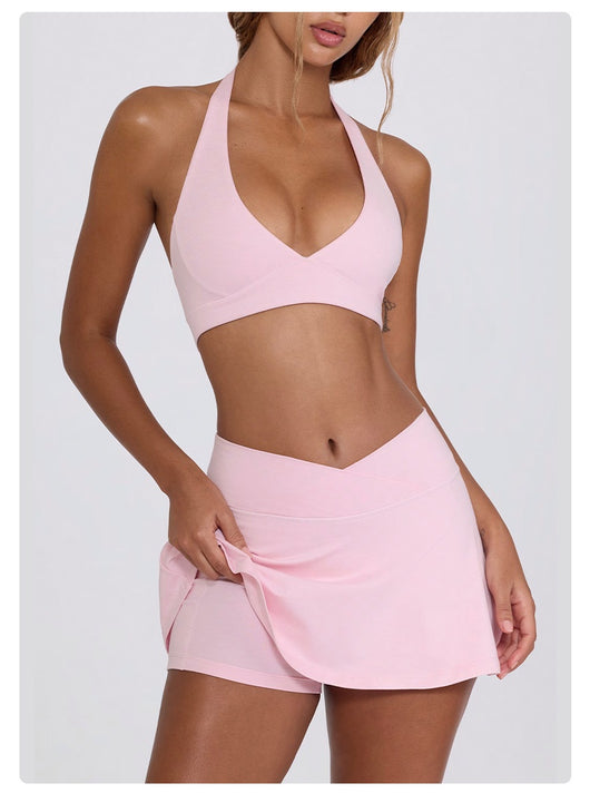 Light pink halter neck sports bra and high-waisted leggings workout set on a model. - Image 43
