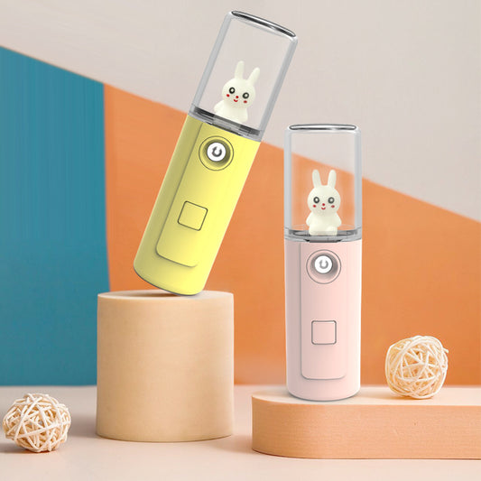 Green portable facial mister with a clear top and a white cartoon rabbit figure inside, featuring a power button.