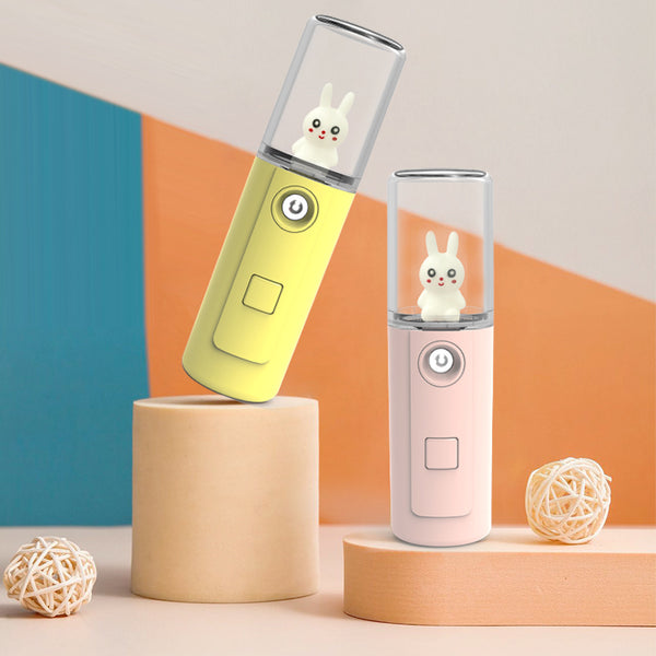 Green portable facial mister with a clear top and a white cartoon rabbit figure inside, featuring a power button.