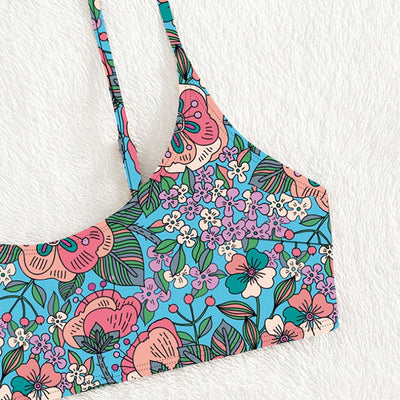 New printed bikini swimsuit with a vibrant floral pattern on a light blue background, featuring a scoop neck top and high-cut bottom. - Image 18
