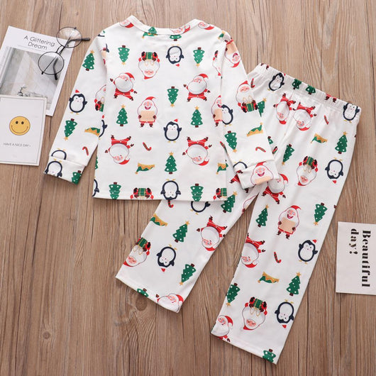 Family of four wearing matching white Christmas pajamas with Santa, penguin, reindeer, and tree print. - Image 7