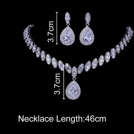 Silver-toned necklace and earring set with red teardrop stones and clear marquise-cut accents on a black display. - Image 9