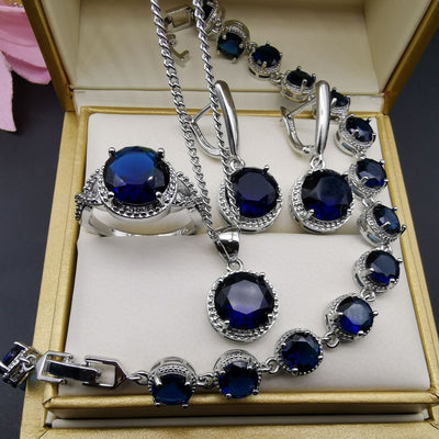 Four-piece silver-tone jewelry set with round green gemstones, including a necklace, bracelet, ring, and dangle earrings. - Image 6