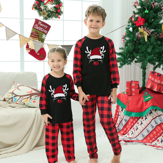 Matching family Christmas pajamas with black tops, red and black plaid sleeves, and glittery leopard print Christmas trees.