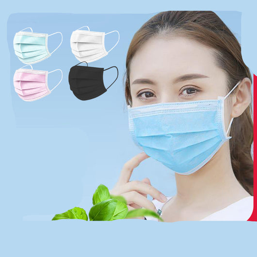 Stack of black disposable 3-ply face masks with ear loops, and one mask laid flat on a light wood surface. - Image 9