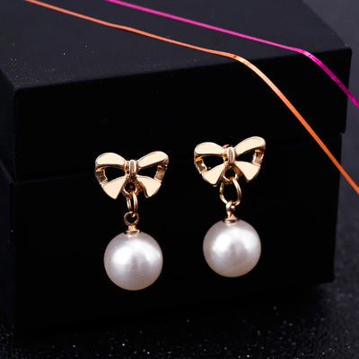 Aretes Elegantes de Corazón con Moño de Circonia y Perla - Image 9