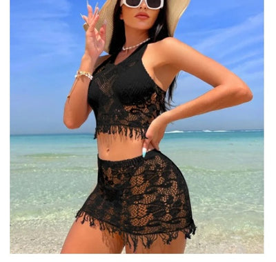 Woman wearing a black lace two-piece beach cover-up with a halter crop top and mini tassel skirt on a sunny beach. - Image 8