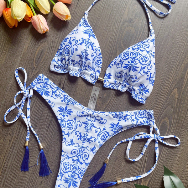 Women's blue and white porcelain print halter bikini with tie-side bottoms and blue tassels.
