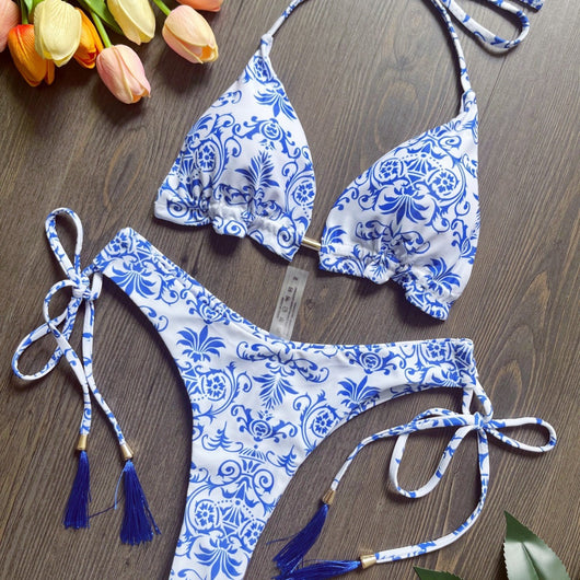 Women's blue and white porcelain print halter bikini with tie-side bottoms and blue tassels.