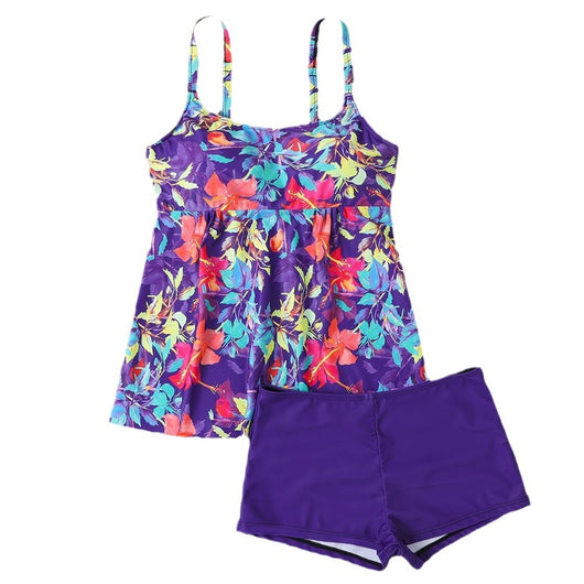 Woman in a black and white abstract print tankini top with black swim shorts on a sunny beach. - Image 5