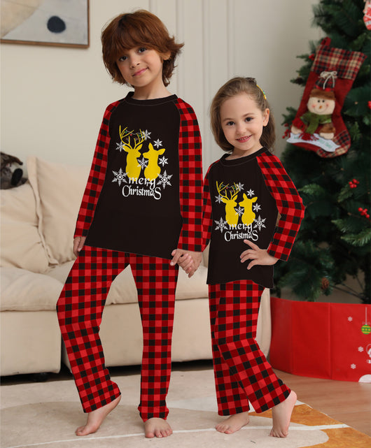 Two children in matching black and red buffalo plaid Christmas pajamas with golden deer and "Merry Christmas" print. - Image 13