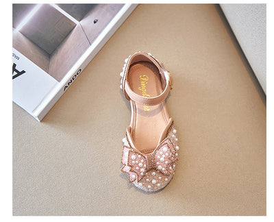 Beige girls' shallow mouth pumps with a large pink pearl bow, glitter, and an ankle strap with a gold buckle. - Image 17