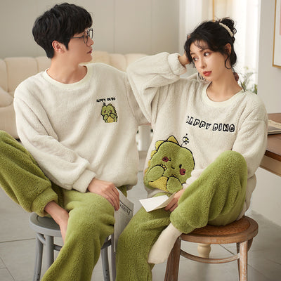 Couple wearing matching cream coral fleece pajamas with gray pants and bear embroidery, seated on a bed. - Image 2