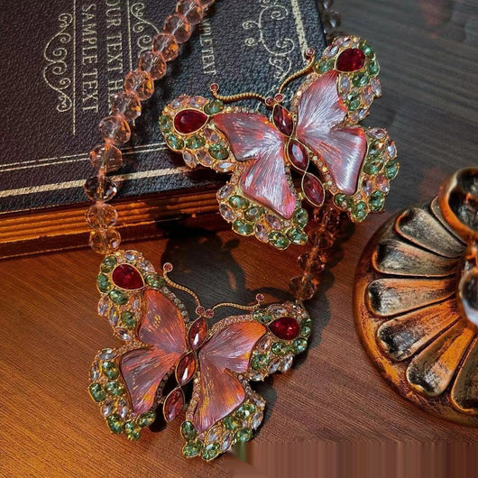Pink enamel butterfly brooch with green, red, and clear rhinestones set in gold-toned metal. - Image 12