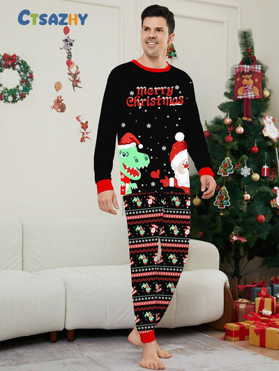 Man wearing black Christmas pajamas with a cartoon dinosaur, Santa Claus, and "Merry Christmas" text, standing by a decorated tree. - Image 30