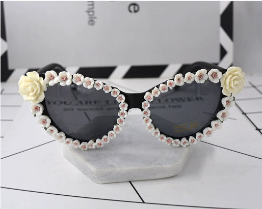 Black cat-eye sunglasses with dark lenses, adorned with small red rose embellishments along the frames. - Image 7