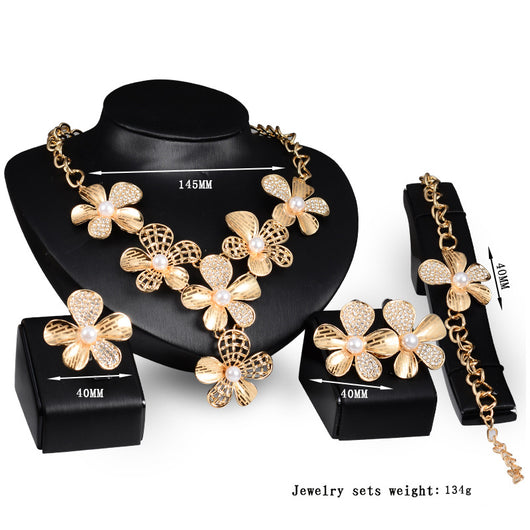 Gold-tone four-piece jewelry set with flower motifs, featuring a necklace, bracelet, ring, and earrings, all with faux pearls and clear rhinestones. - Image 7
