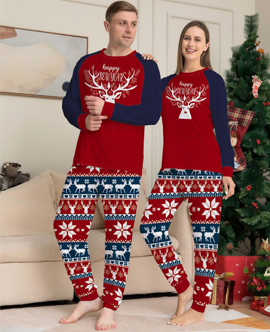 Child wearing a red and navy blue Christmas pajama set with a white reindeer and "happy NEW YEAR" text on the top, and fair isle pattern pants. - Image 3