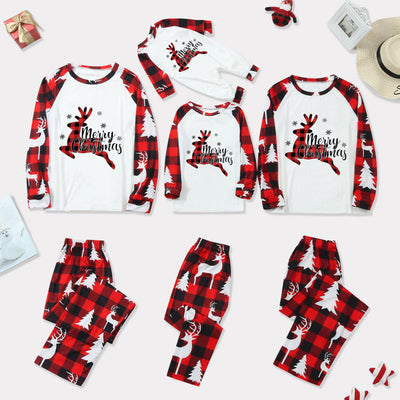 Family matching Christmas pajamas with red and black buffalo plaid, white reindeer, and Christmas tree prints.