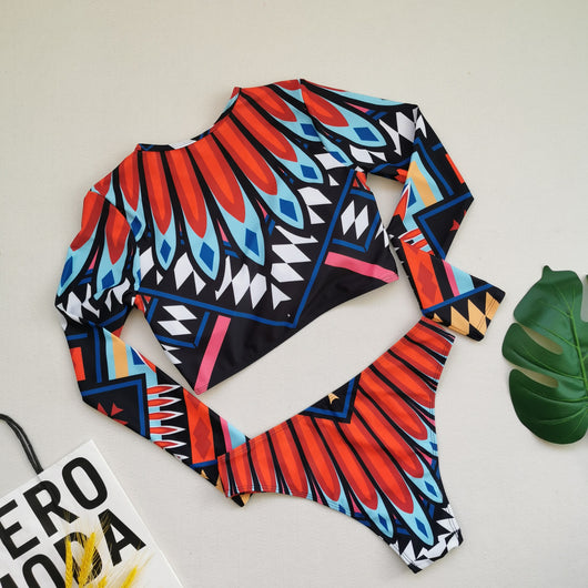 Women's long-sleeve crop top and high-waisted bikini set with a vibrant red, blue, black, and white feather-like geometric pattern. - Image 11