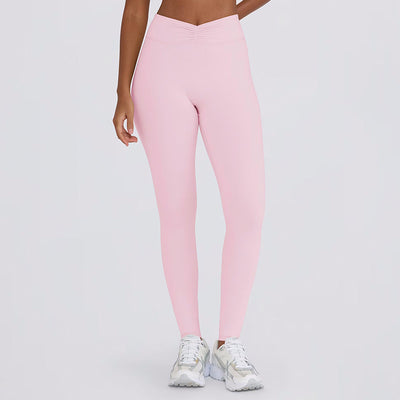 Light pink halter neck sports bra and high-waisted leggings workout set on a model. - Image 24