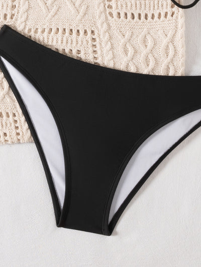 Black and white printed triangular cup tie bikini top with solid black bottoms, displayed with a knit tote bag and sunglasses. - Image 15