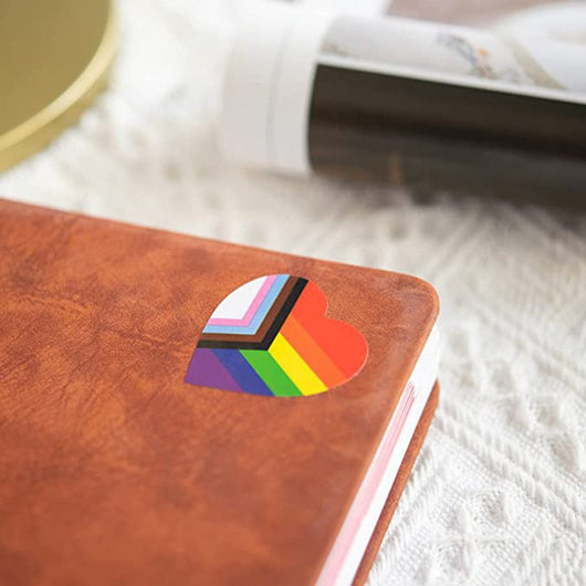 Roll of heart-shaped stickers featuring the Progress Pride flag design with rainbow and chevron stripes. - Image 22