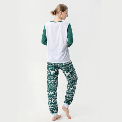 Woman in a Christmas pajama set with a white top, green sleeves, dinosaur graphic, and green fair isle pants. - Image 29
