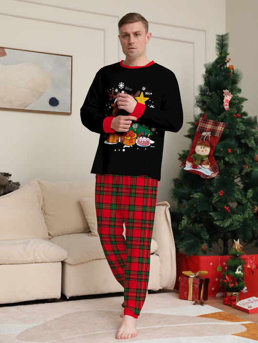 Two children in black and red plaid Christmas pajamas with a reindeer and Christmas tree graphic, standing by a Christmas tree. - Image 11