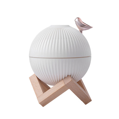 White spherical humidifier with ribbed texture, warm glow, metallic bird accent, and light brown wooden stand. - Image 8
