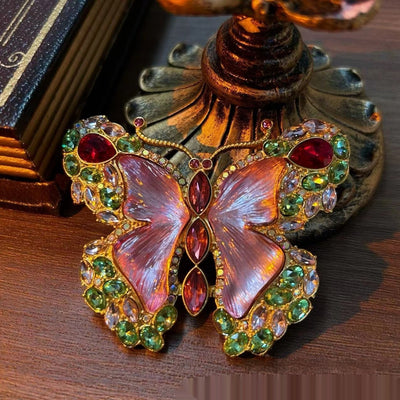 Pink enamel butterfly brooch with green, red, and clear rhinestones set in gold-toned metal. - Image 10