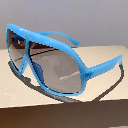 Oversized women's shield sunglasses with a tortoiseshell frame and brown-tinted lenses, held by a hand. - Image 19