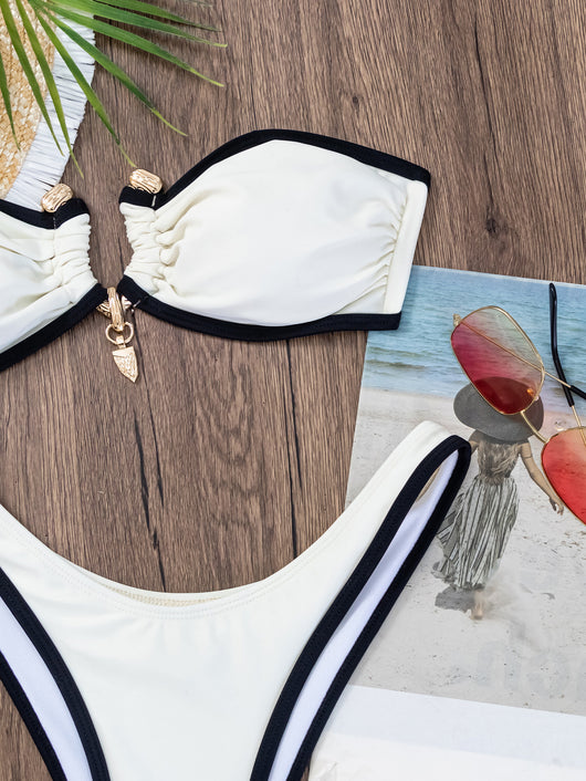 Women's white and black color-contrast tube top bikini with gold-tone hardware, modeled by a pool. - Image 12