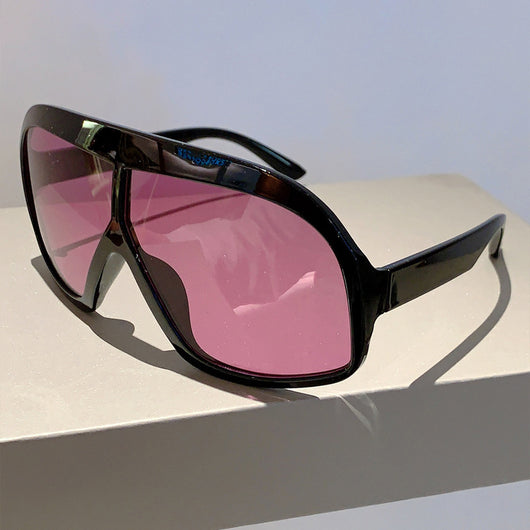 Oversized women's shield sunglasses with a tortoiseshell frame and brown-tinted lenses, held by a hand. - Image 14