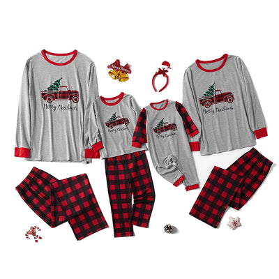 Family Christmas pajama set with grey long-sleeve tops featuring a red truck with a tree, and red and black buffalo plaid pants. Includes adult, kids, and baby