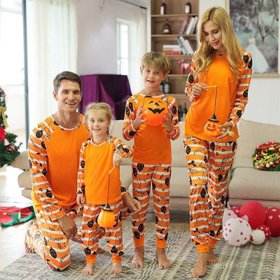 Family of four wearing matching orange and white striped Halloween pajamas with pumpkin and bat prints. - Image 9