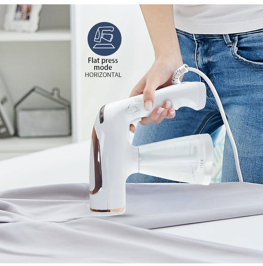 White and gold handheld folding steam iron with clear cistern, long bristle brush, fluff brush, and measuring cup. - Image 17