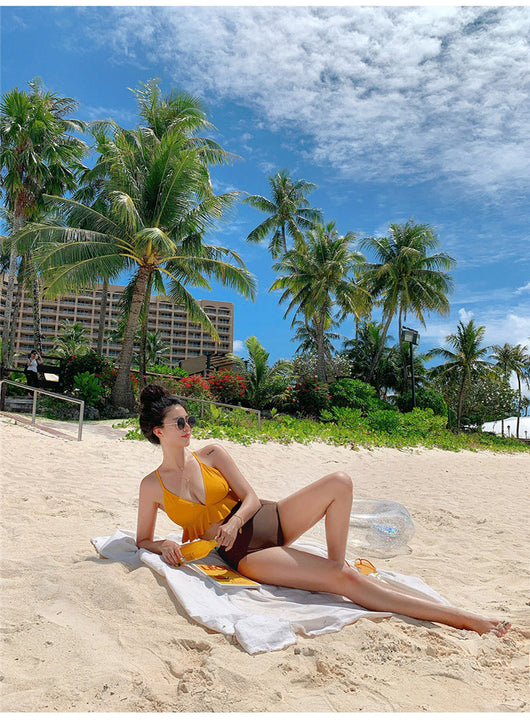 Woman in a yellow ruffled bikini top and dark brown high-waisted bottoms sitting on a beach. - Image 8