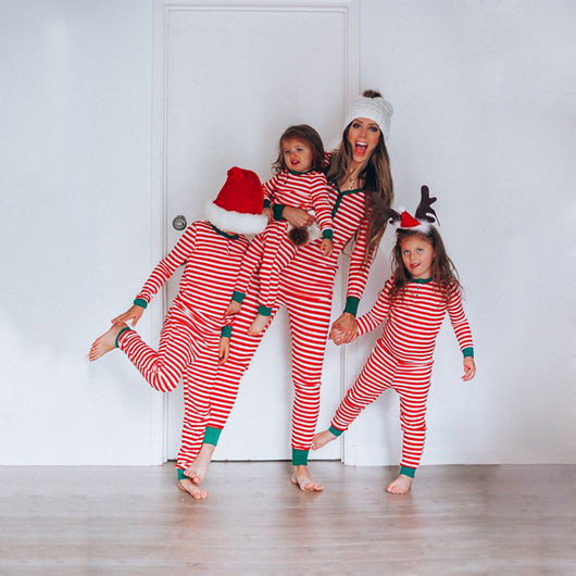 Family of seven wearing matching red and white striped long-sleeved pajamas with green cuffs, some with Santa hats. - Image 12