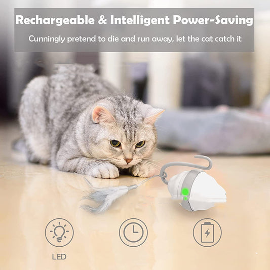 Golden-brown cat playing with a white and grey automatic rolling mouse cat toy with feather-like streamers on a wood floor.