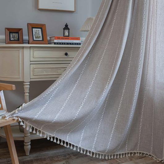 Black polyester curtain with white jacquard multi-line pattern and black tassels, draped over a white chair. - Image 10