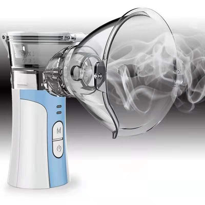 Hand-held compression atomizer with a clear mask and white and blue body, emitting a fine mist.
