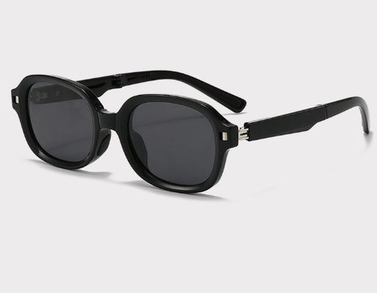 Brown oval sunglasses with dark lenses and thick frames, featuring visible silver hinges on a light gray background. - Image 14