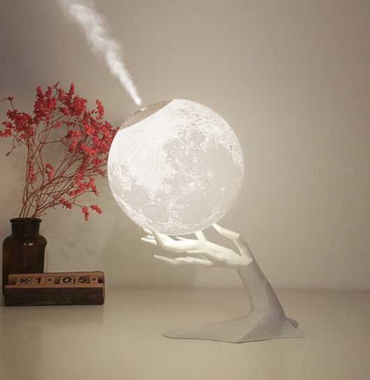 Moon-shaped humidifier and night light with a white deer stand, emitting mist, on a wooden table with books. - Image 10