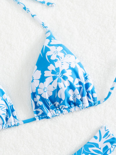 Woman wearing a black and white floral print triangle cup bikini swimsuit on a sunny beach. - Image 16