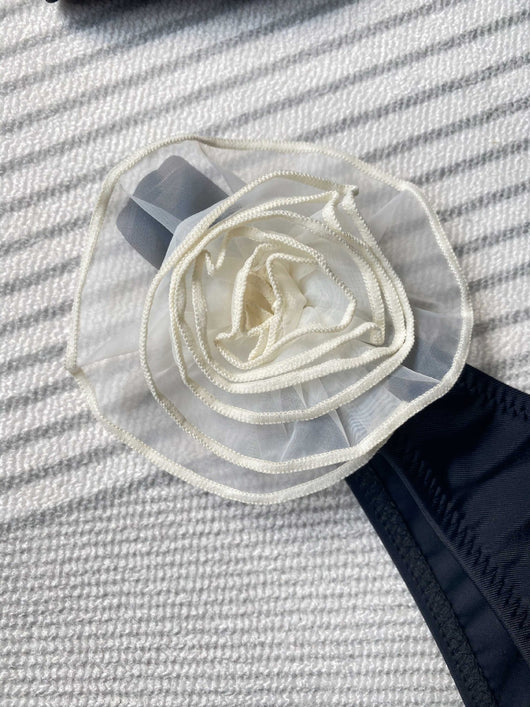 Black tube top bikini with white three-dimensional flower embellishments, worn by a woman partially submerged in water. - Image 11