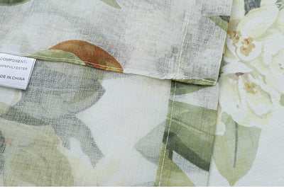 Dark gray semi-sheer curtains with a white and green floral pattern, hung on a black rod in a living room. - Image 9
