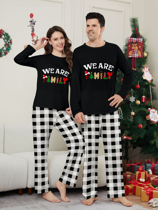 Family of four wearing matching black long-sleeve pajamas with "WE ARE FAMILY" text and black and white plaid bottoms. - Image 14